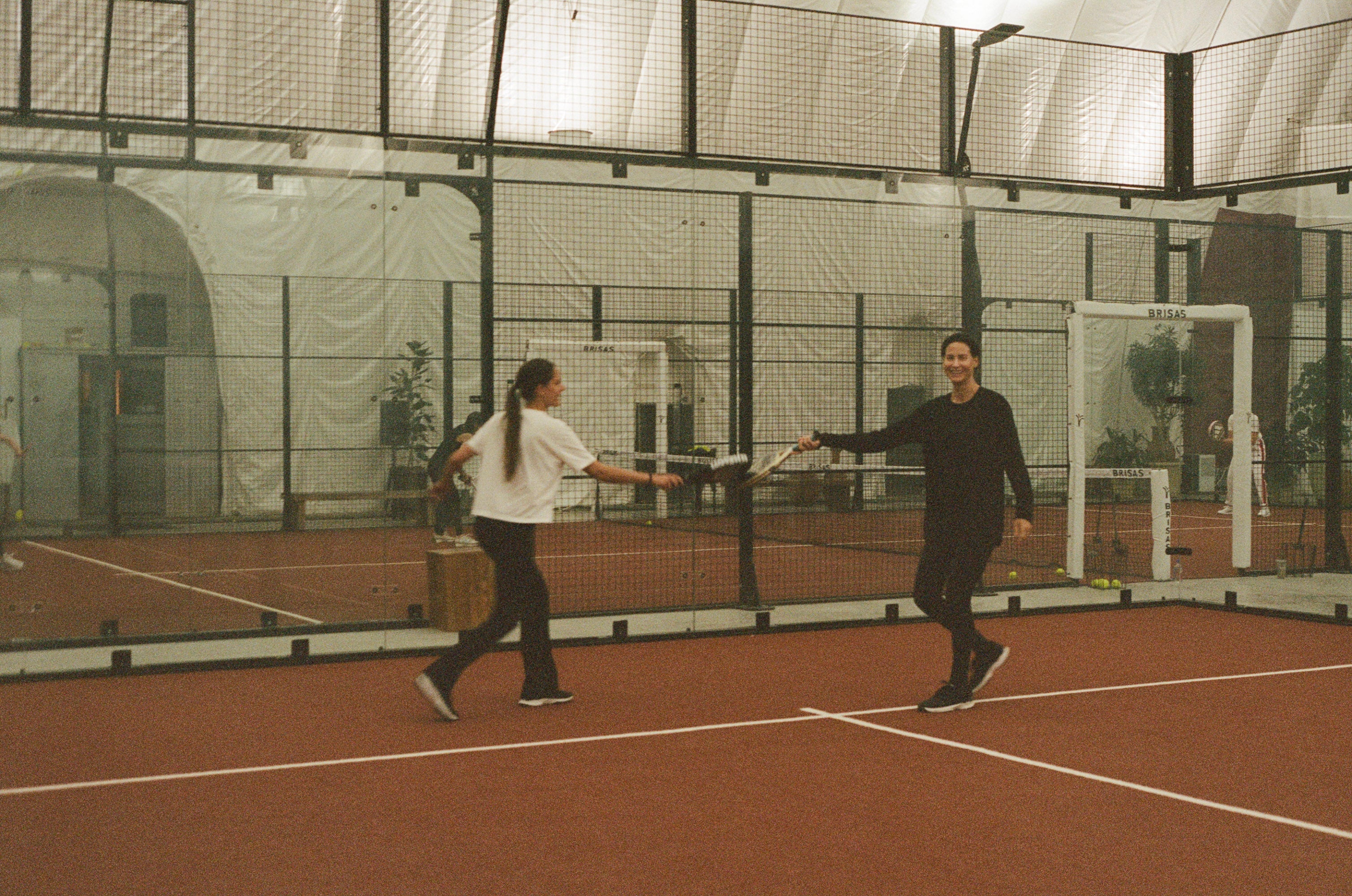 Two players mid rally on a padel court at CityView